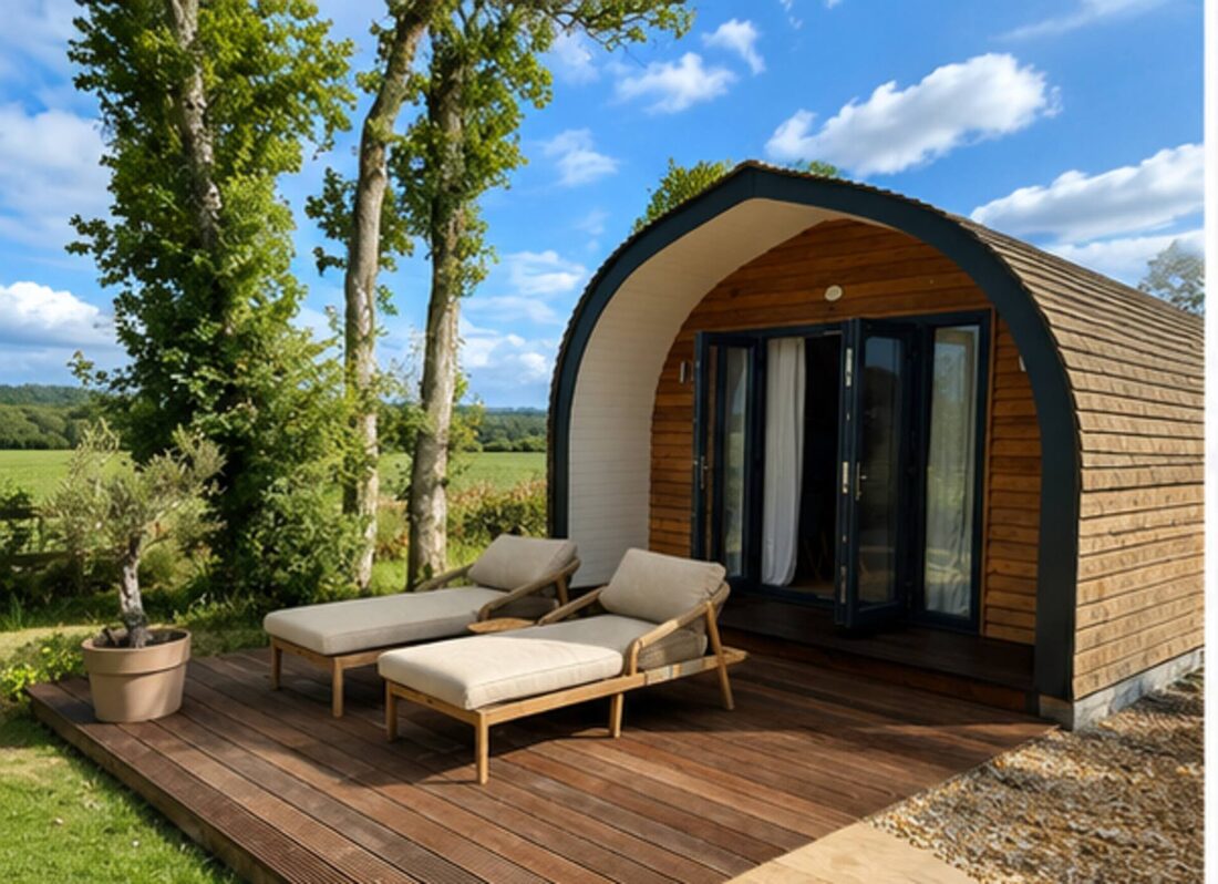 The Old Poultry Shed glamping pod exterior with sun loungers on a deck, set in private lawned grounds near the New Forest