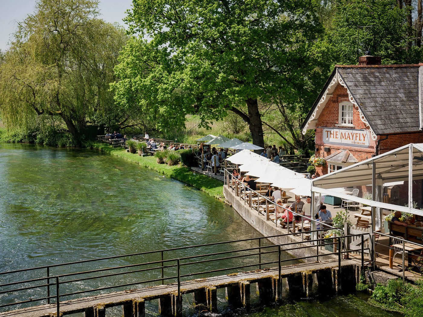 The riverside terrace of The Mayfly pub on the banks of the River Test near Stockbridge